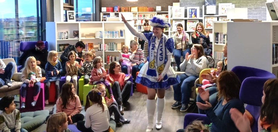 Ein Gardemädchen marschiert zum Vorlesen in die Stadtbibliothek ein