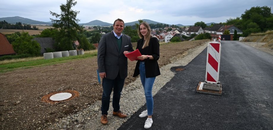Bürgermeister und Madlen Hillenbrand vor Baustraße