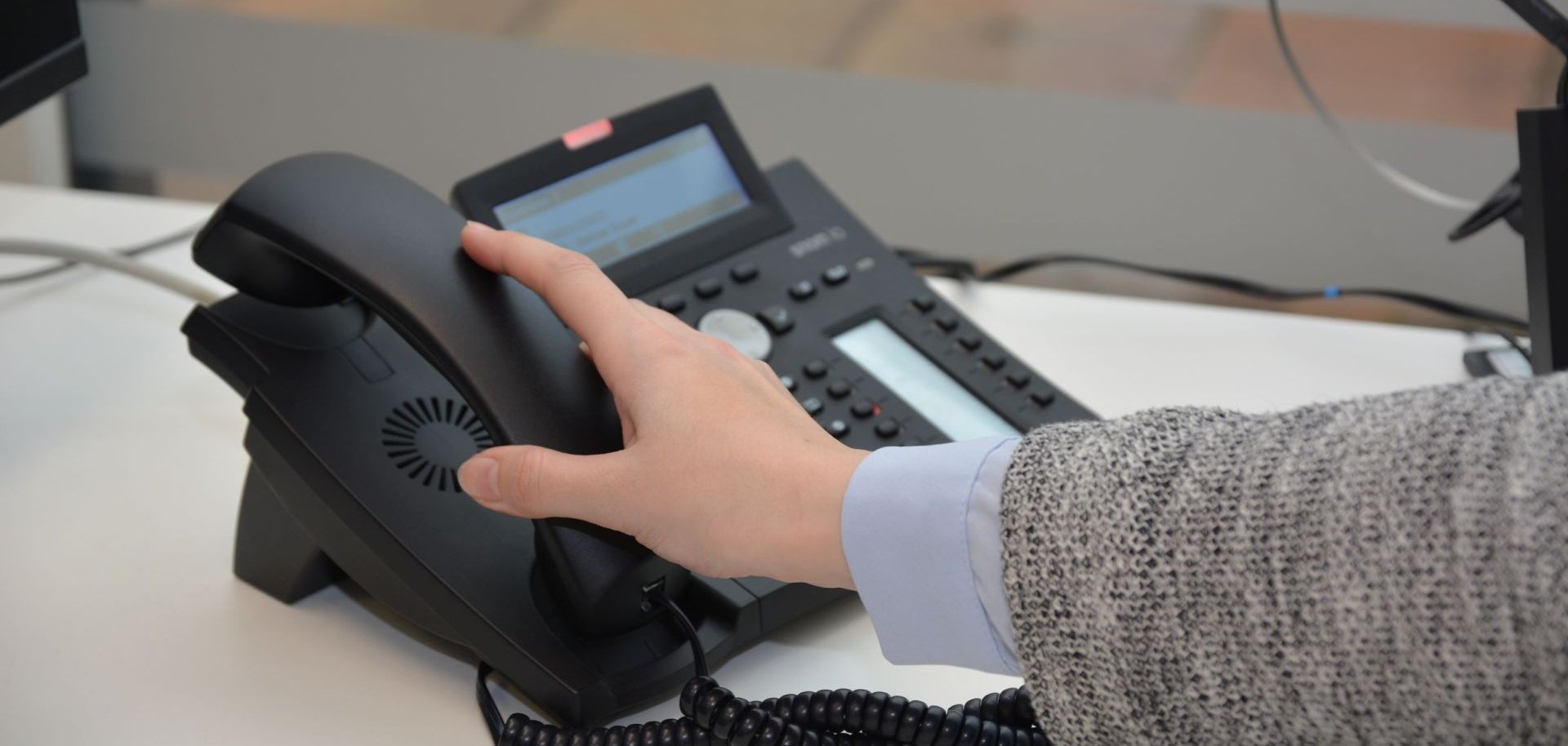 Hand hebt Telefonhörer ab