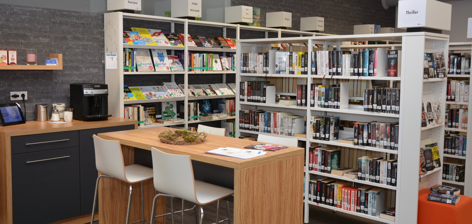 Bücherregale hinter Hochtisch mit zwei Stühlen