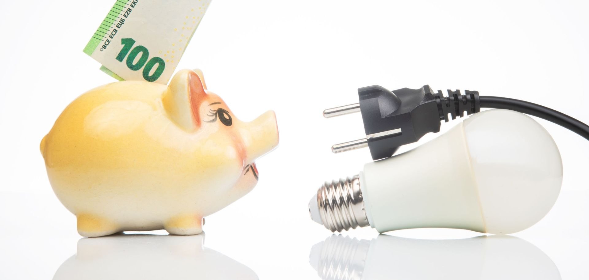 Symbolbild Sparschwein Geldschein und Stromkabel