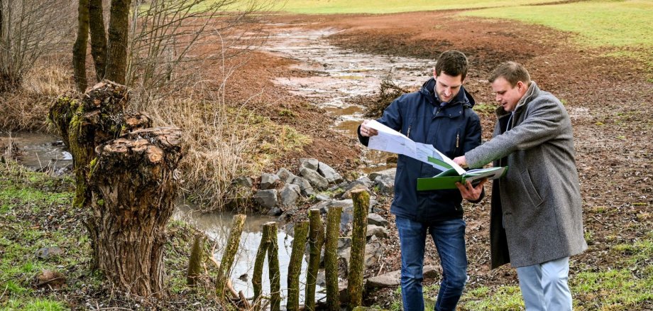 Stefan Albinger und Bürgermeister Benjamin Tschesnok schauen auf einen Plan.