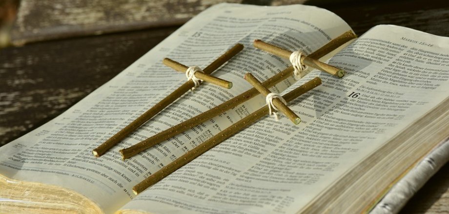 aufgeschlagenes Buch mit Kreuzen