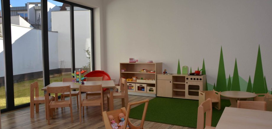 Gruppenraum mit Spielsachen und Holzmöbeln