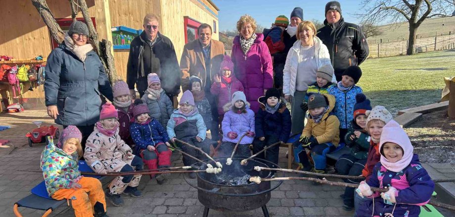 Kinder der Bauernhofgruppe grillen Stockbrot