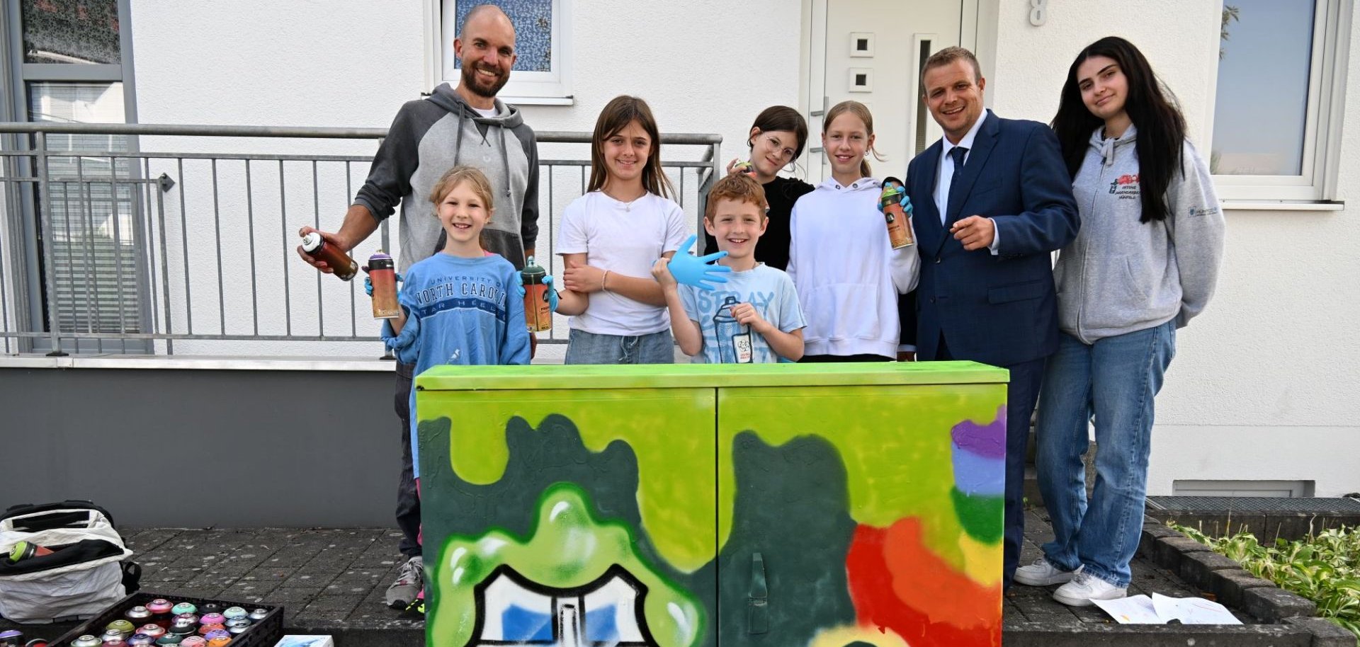 Kinder und Jugendliche mit dem Bürgermeister am Stromkasten