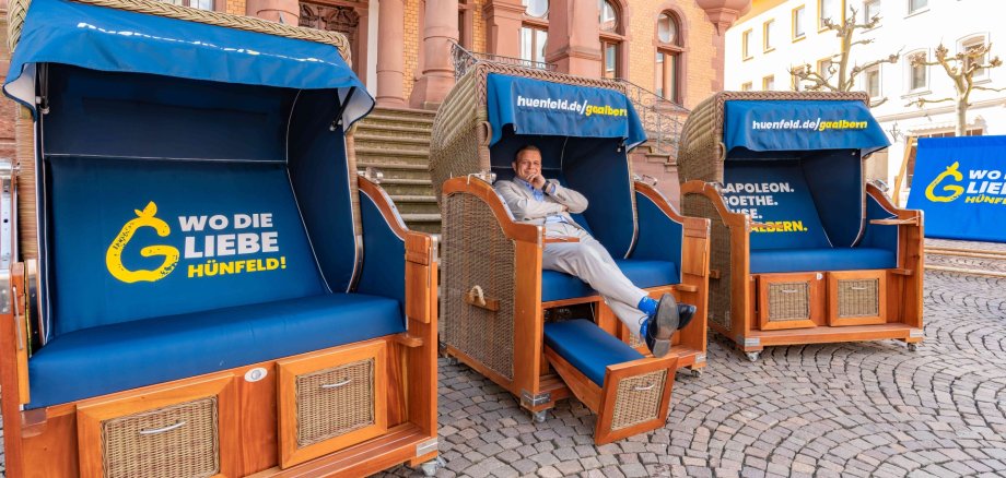 Bürgermeister Benjamin Tschesnok sitzt in einem Strandkorb vor dem Rathaus Hünfeld