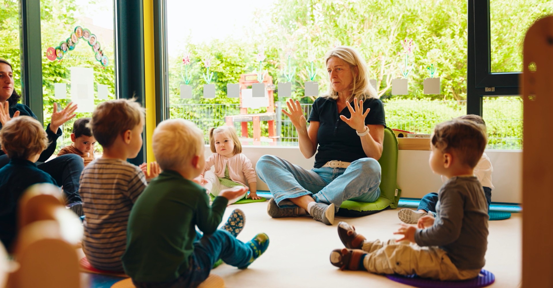 Kindergartengruppe mit Erzieherin im Morgensitzkreis